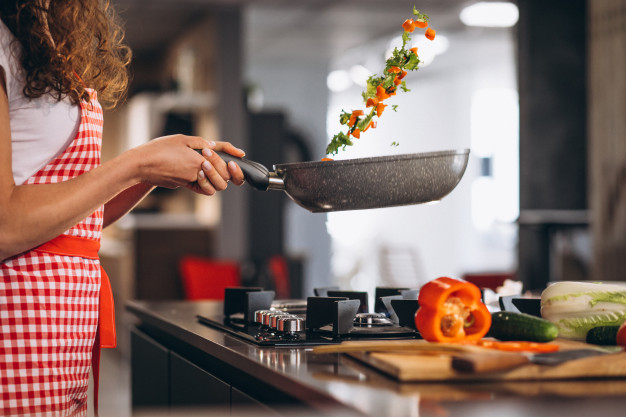 woman-chef-cooking-vegetables-pan_1303-22291